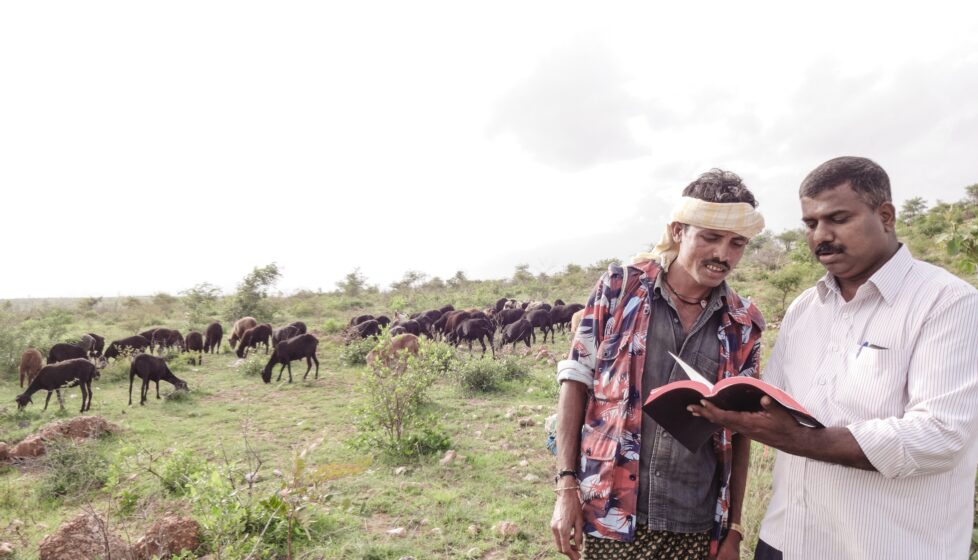 Chandrashekar sharing the gospel with another man and reading him the bible