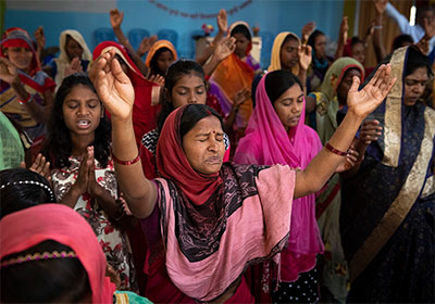 Group of people holding hands up in worship